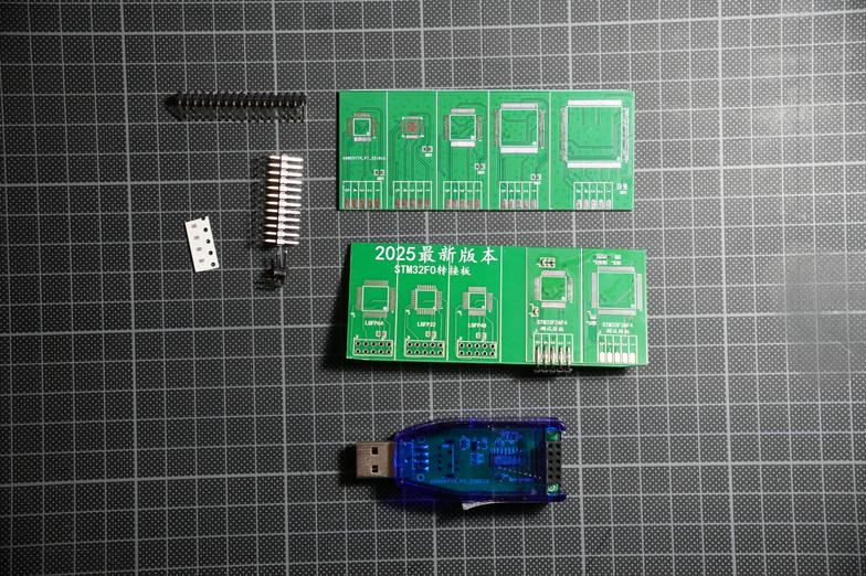 All components laid out on a cutting mat: USB dongle, two adapter PCBs, pin headers and connector